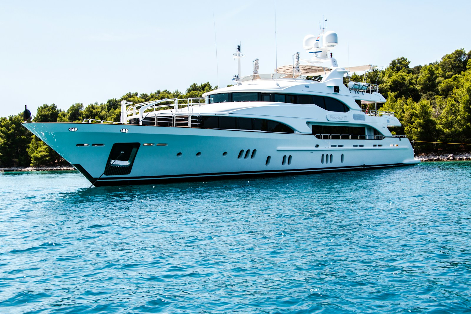 Photo by Marcin Ciszewski white and black yacht on body of water surrounded with tall and green trees